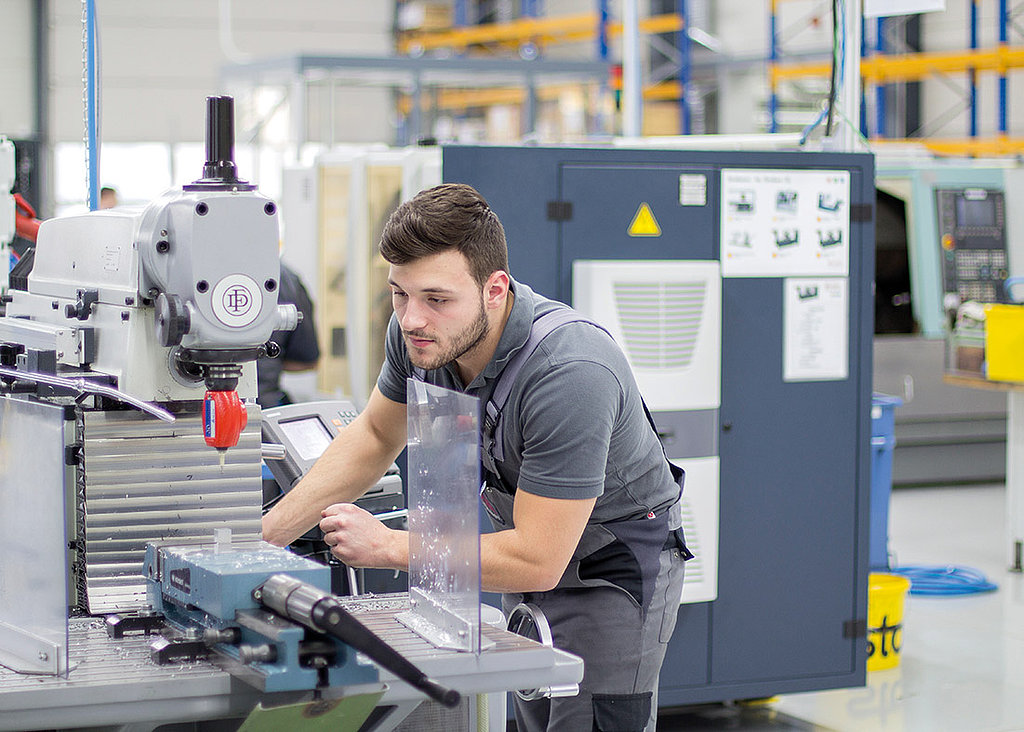 Auszubildender an Bohrmaschine in Lehrwerkstatt bei Blum-Novotest